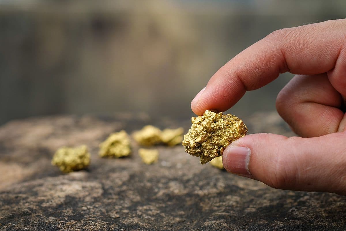 Närbild på hand som håller i rent guld