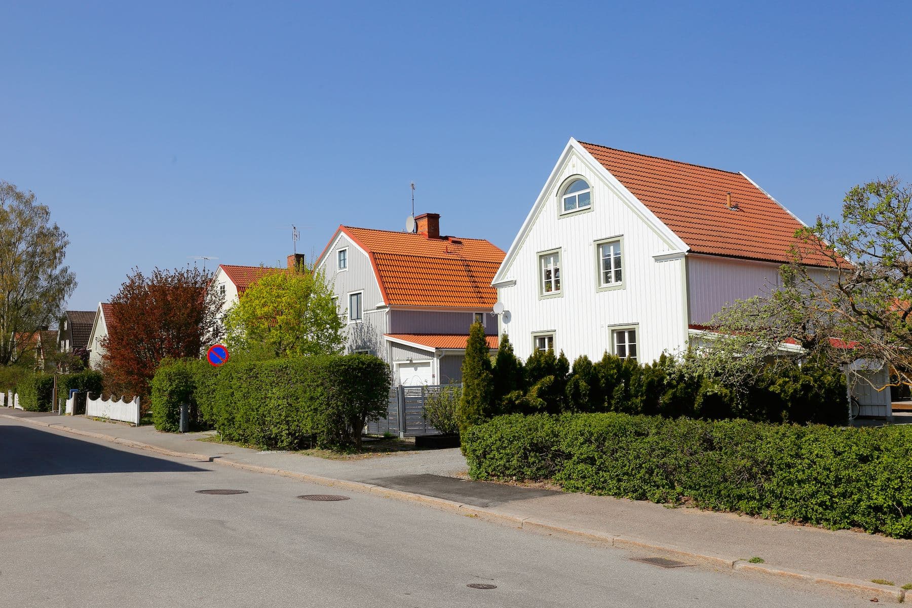 Husfasad med träd och sol i bakgrunden