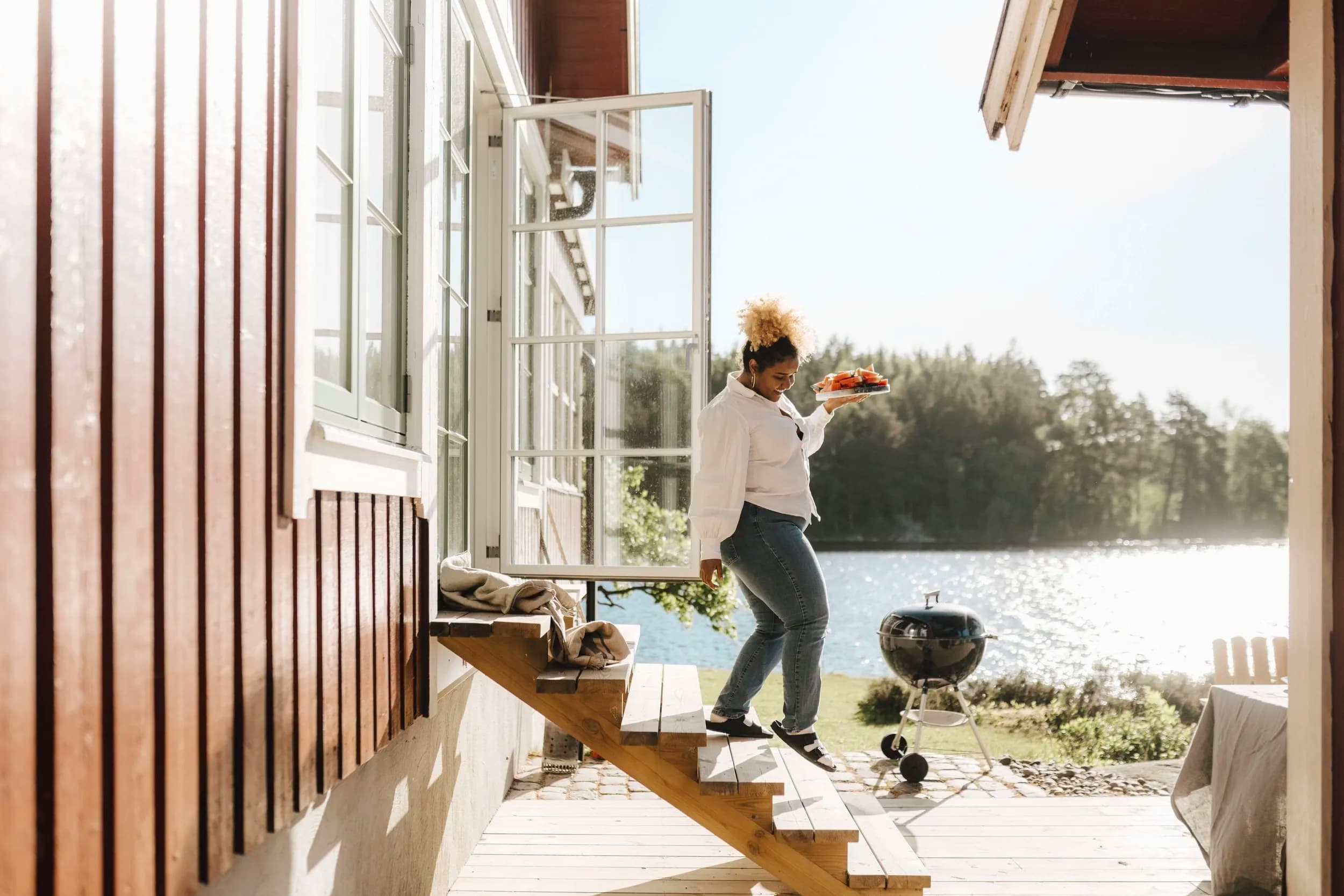 Kvinna går ner för trappa och njuter av nybggd altan i sommarsolen