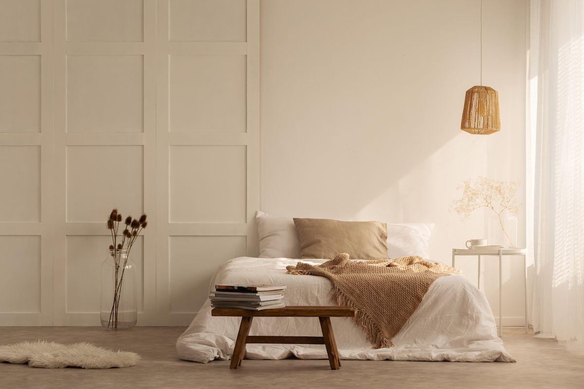 Ett sovrum inrett i minimalistisk stil. Vita väggar och harmoniska färger.