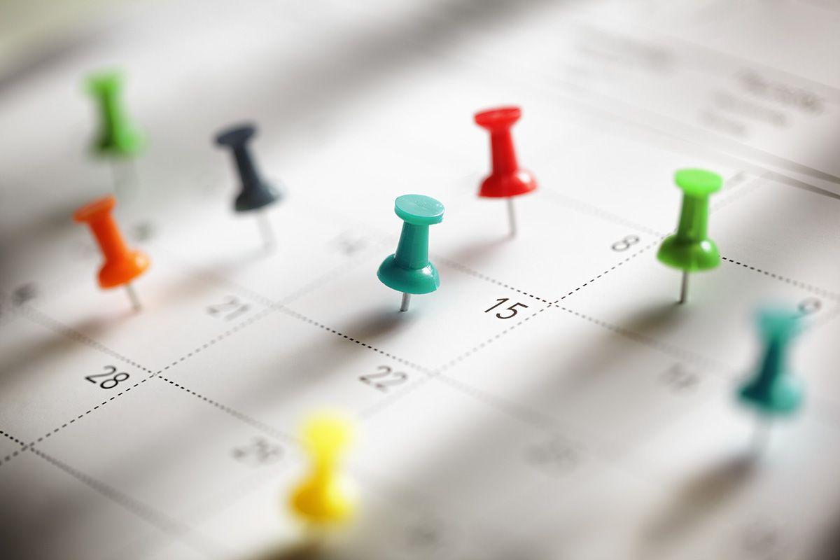 Häftstift pinnade på flera datum i en jobbkalender