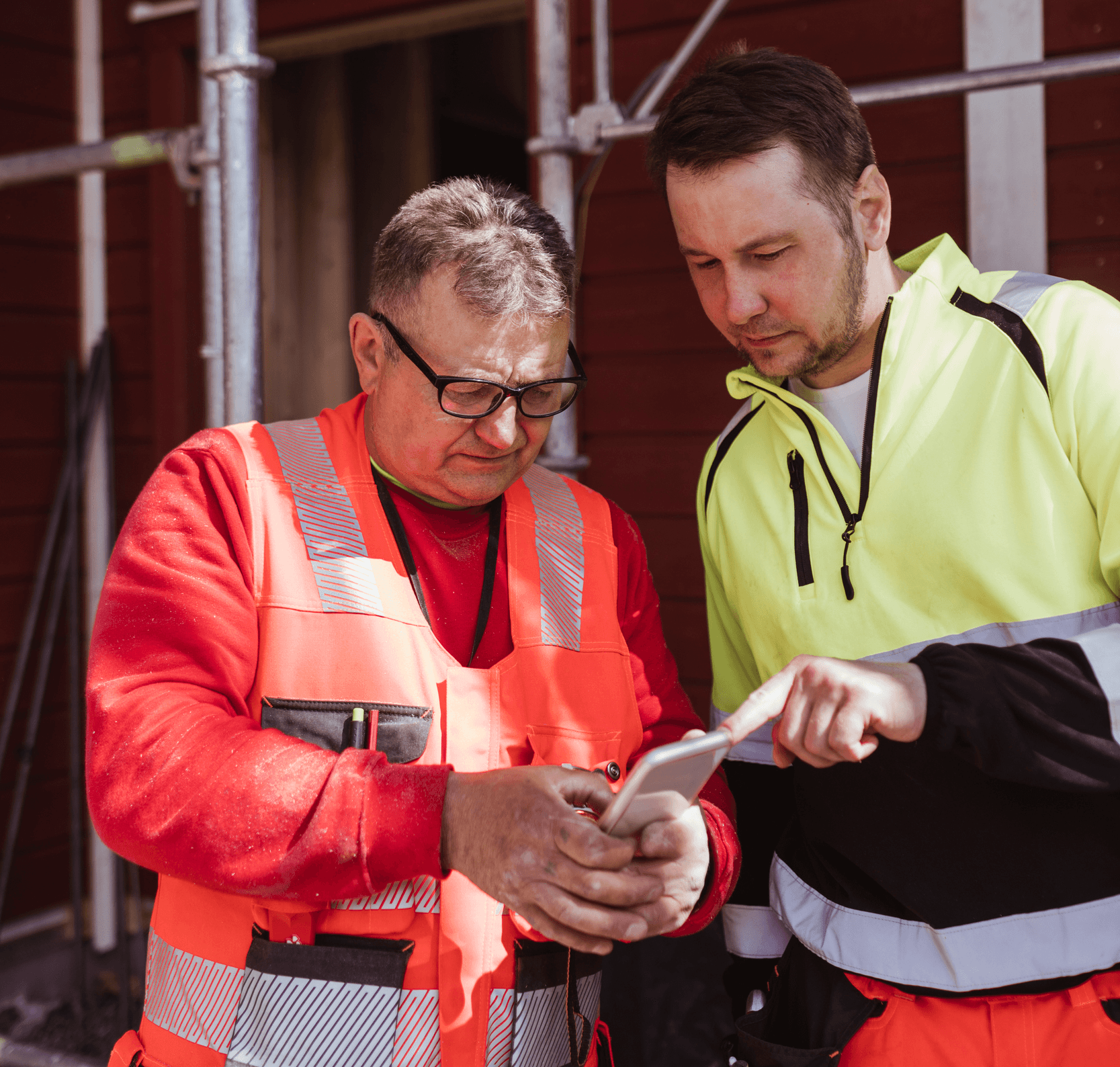 Två hantverkare i arbetskläder som driver byggfirma läser omdömen om sitt företag på Offerta