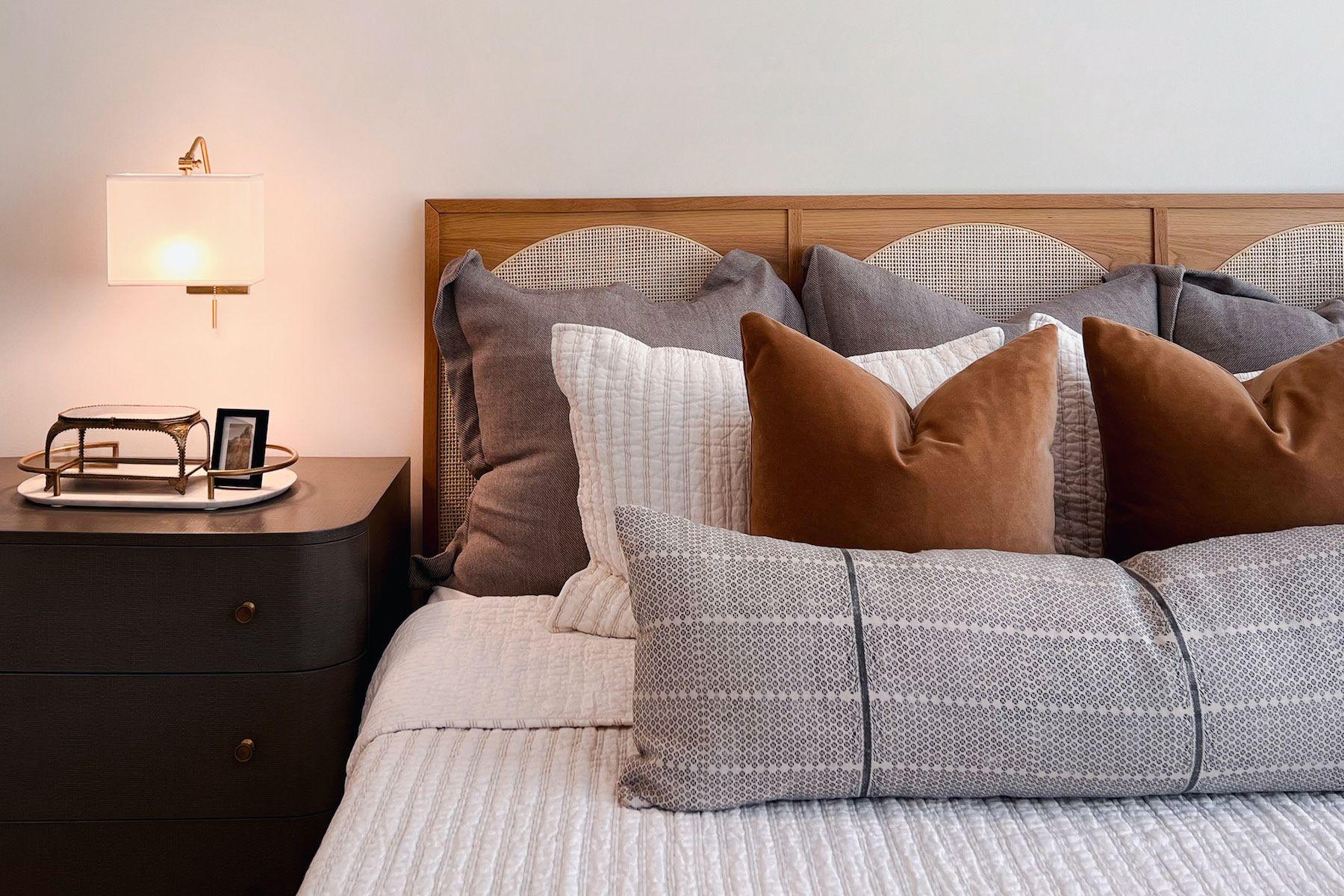 Sovrum med höstfärger och sänggavel i trä och grå sängkläder