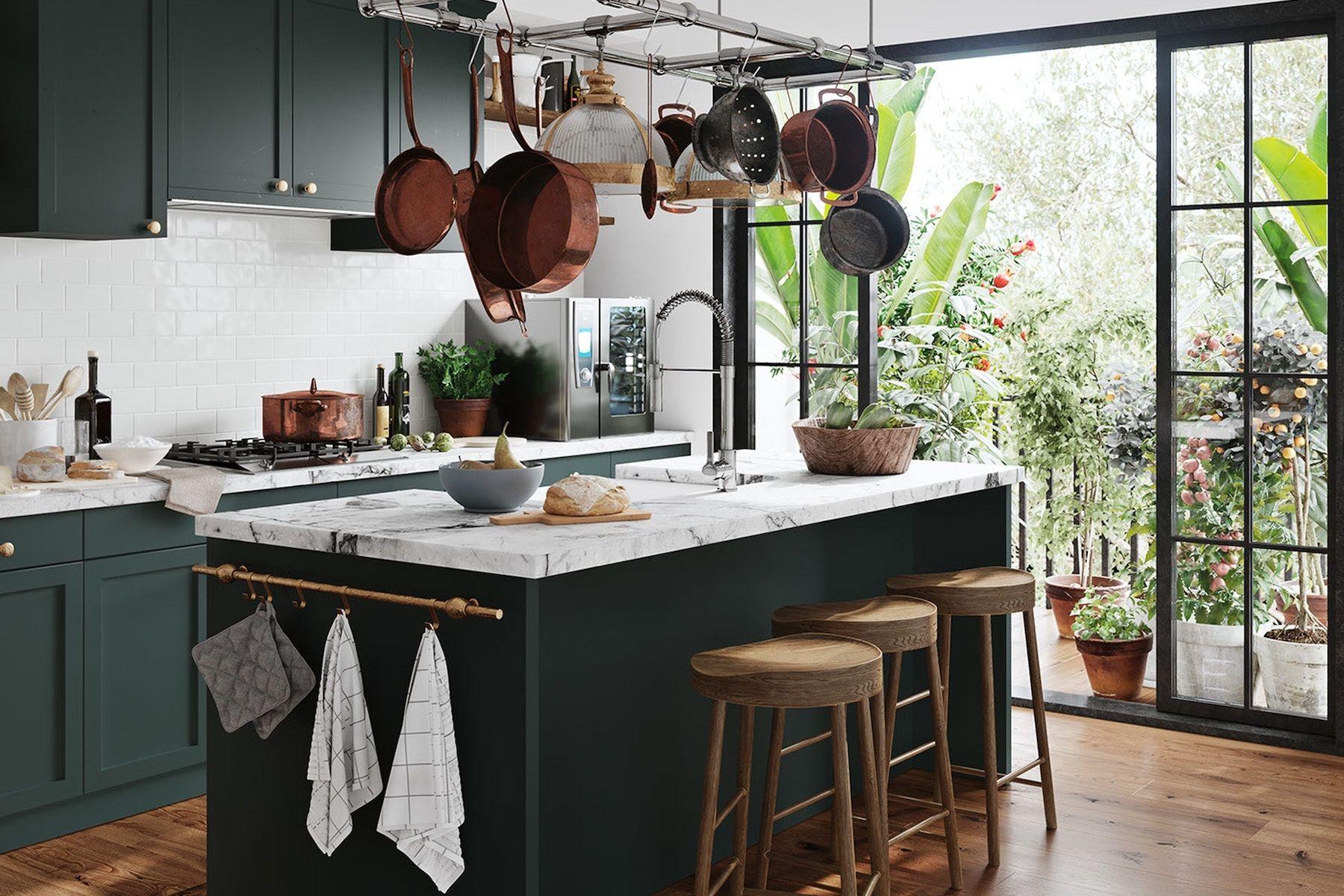 Mörk grönt kök med marmor, kastruller och köksredskap hänger från taket