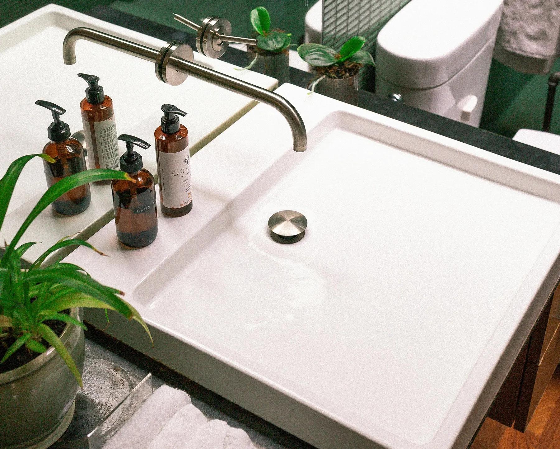 Närbild på modern kommod i nyrenoverat badrum och blandare i rostfritt stål