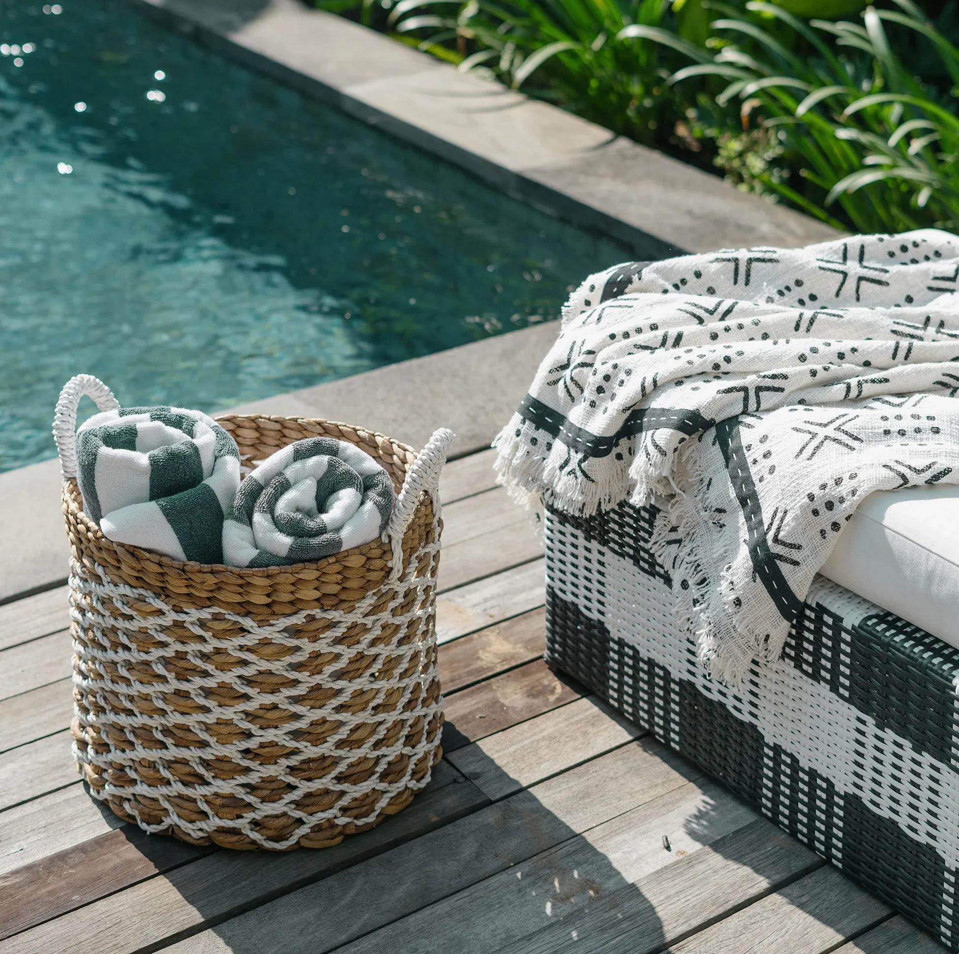 Lyxig poolmiljö med solbäddar och snyggt ordnade randiga handdukar bredvid en inbjudande pool omringad av trädäck skapat av erfarna poolbyggare