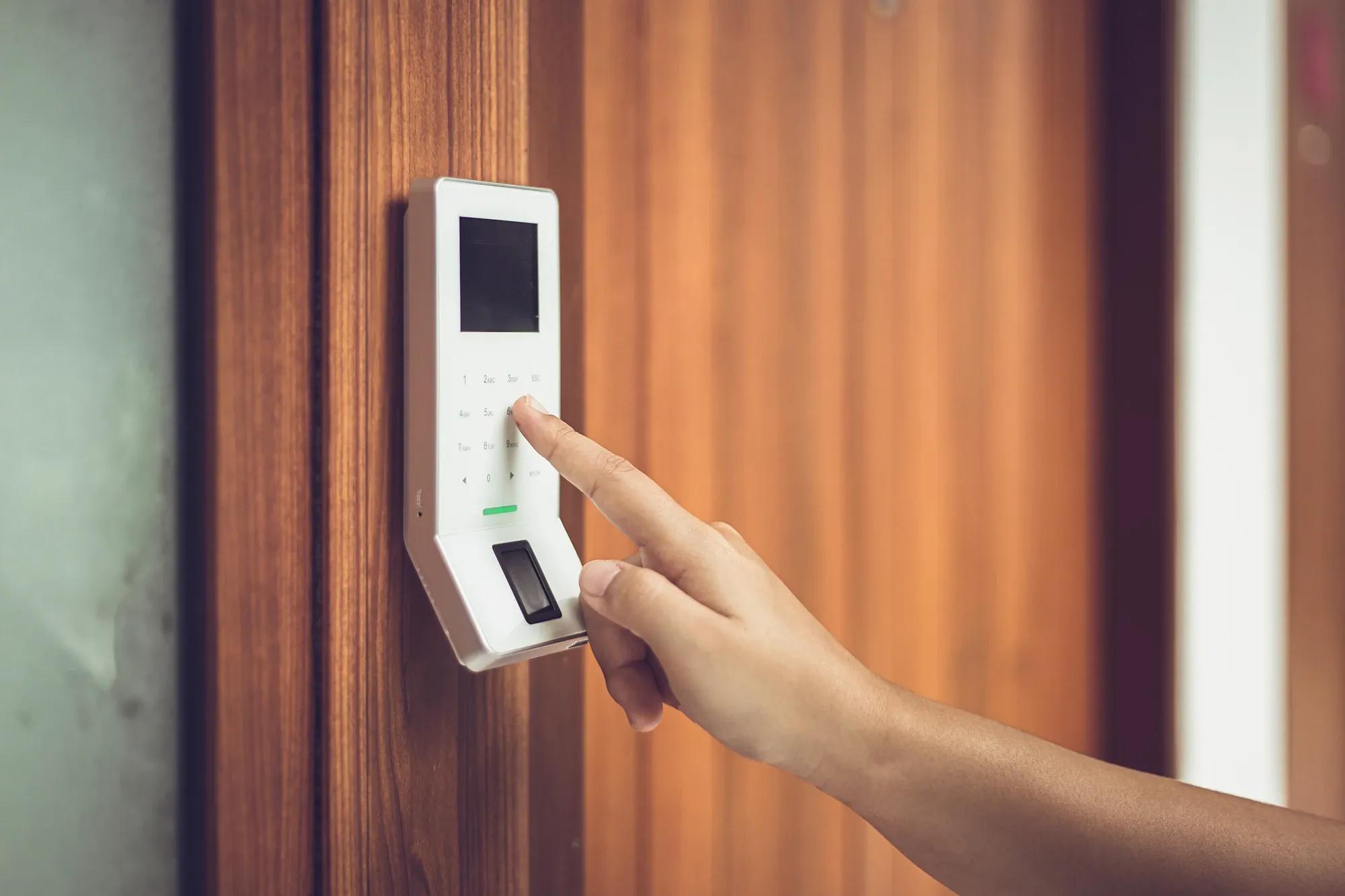 Närbild på hand som knappar in kod för hemlarm illustrerar lås- och larmlösningar med fokus på säkerhet och professionell trygghet för ditt hem eller företag