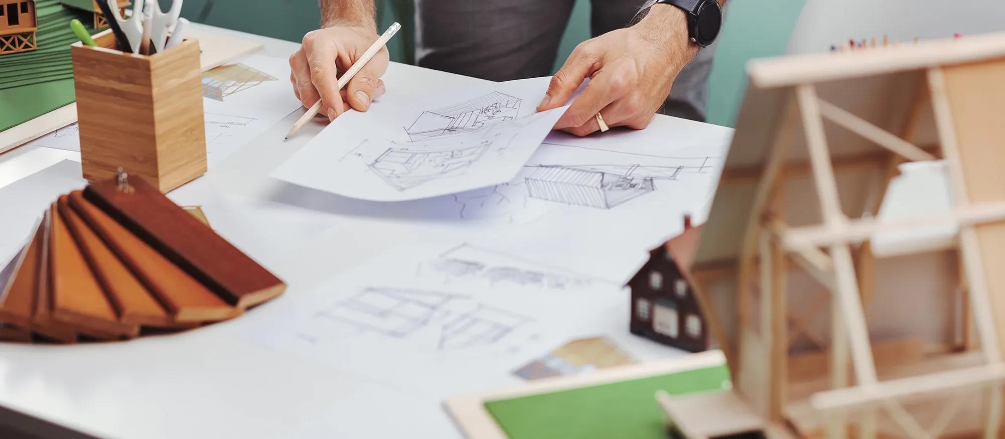 Arkitekt arbetar med bygglovsritning och med husmodeller
