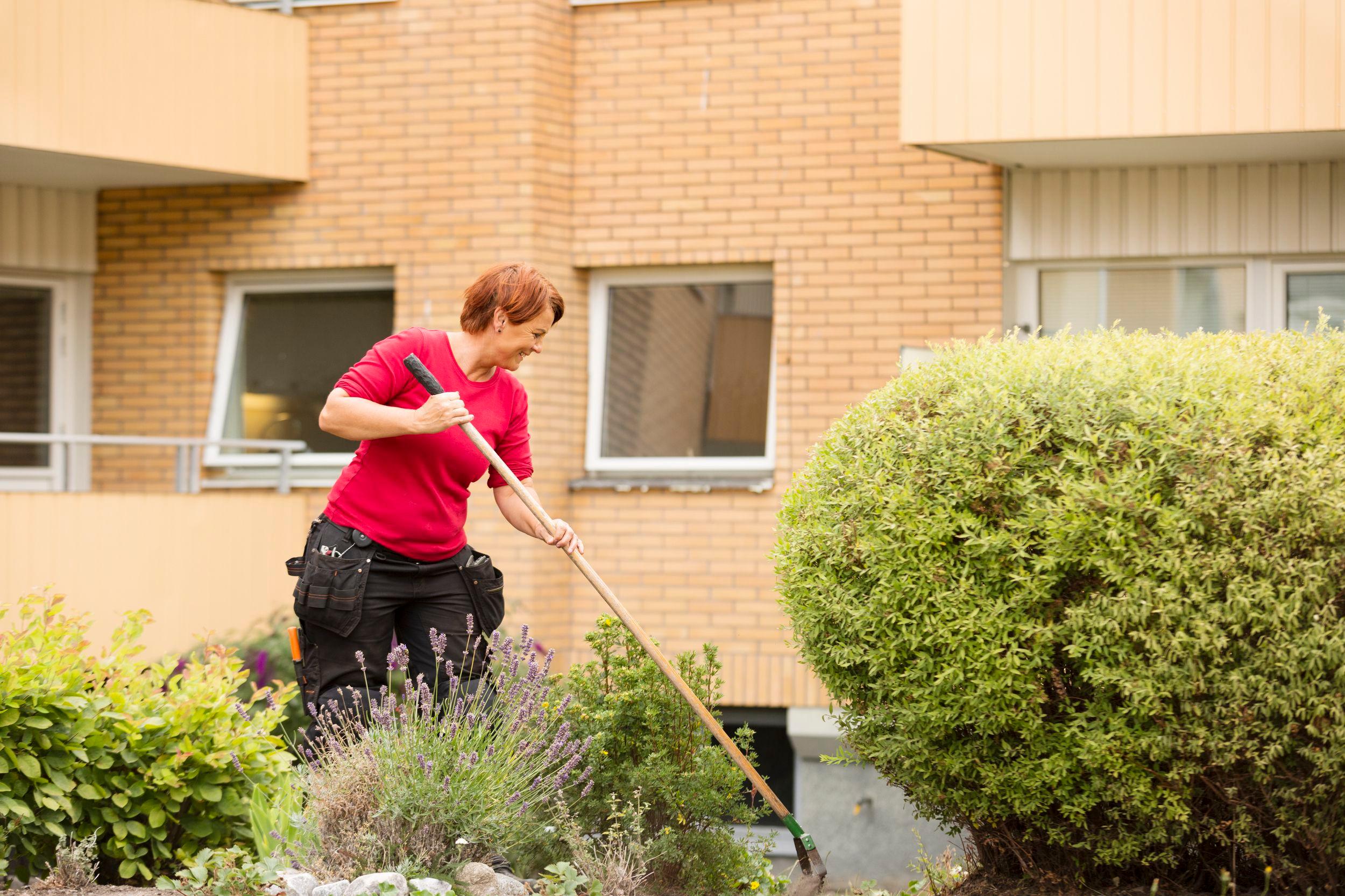 Fastighetsskötare arbetar i trädgården