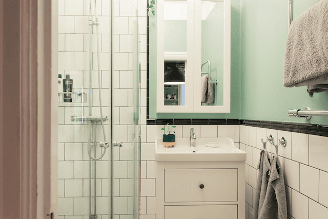 Dusch, badrumskommod med spegel med mintgröna väggar