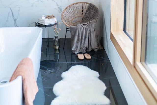 Snyggt badrum med marmorgolv, väggar och badkar