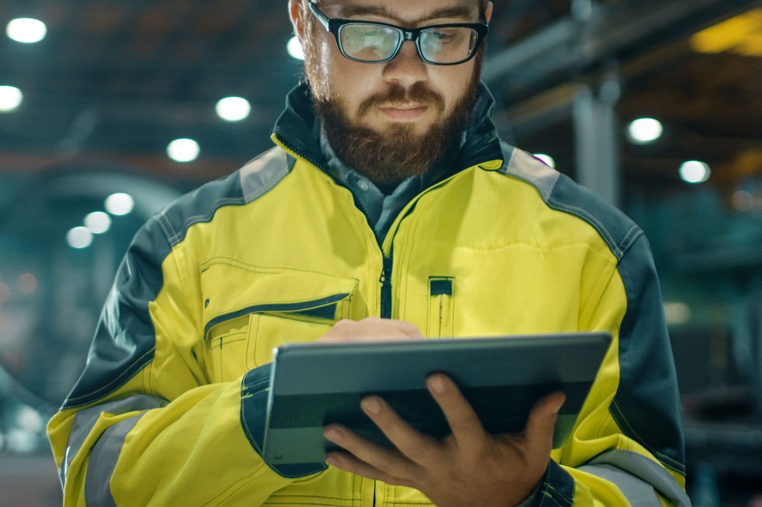 Byggarbetare i arbetskläder arbetar via padda