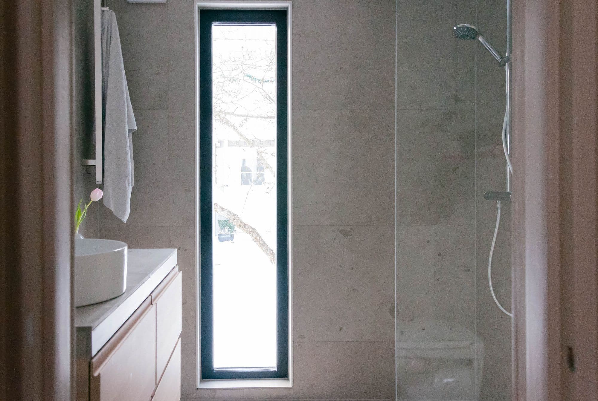Efterbild av renovering i badrum i hus, avlångt fönster och duschvägg