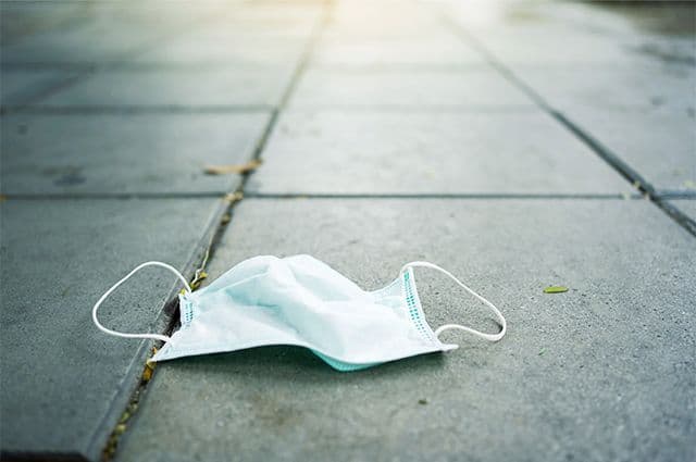 Coronamask ligger slängd på gata