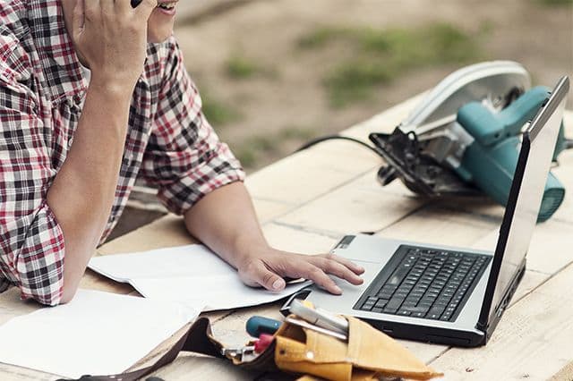 Modern och digital hantverkare kollar efter uppdrag på datorn på Offerta.se