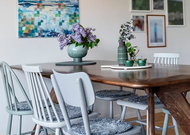 Kvinna sätter blommor i en vas i sitt nyrenoverade kök